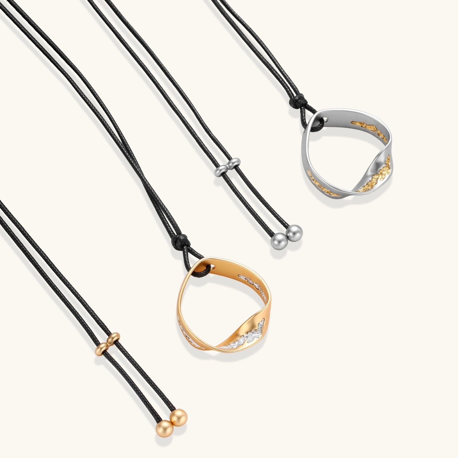 Geometric circle pendant necklace with crystal cluster on adjustable black cord, available in gold and silver finishes.